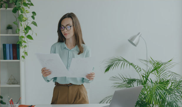 Happy smiling elegant woman with book in a blue armchair in the living room, sunny day