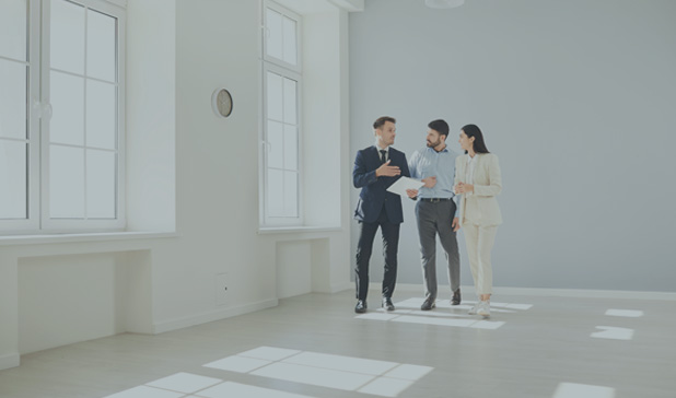 Male real estate agent in a suit showing a new apartment to potential buyers